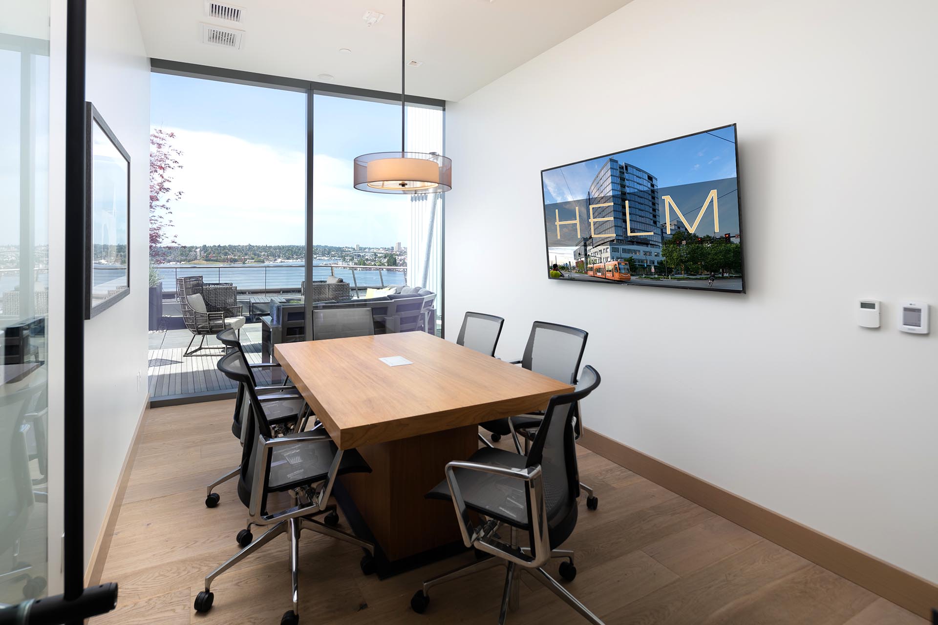 A small, well lit office space with a wall of glass and the city/lake in view from within