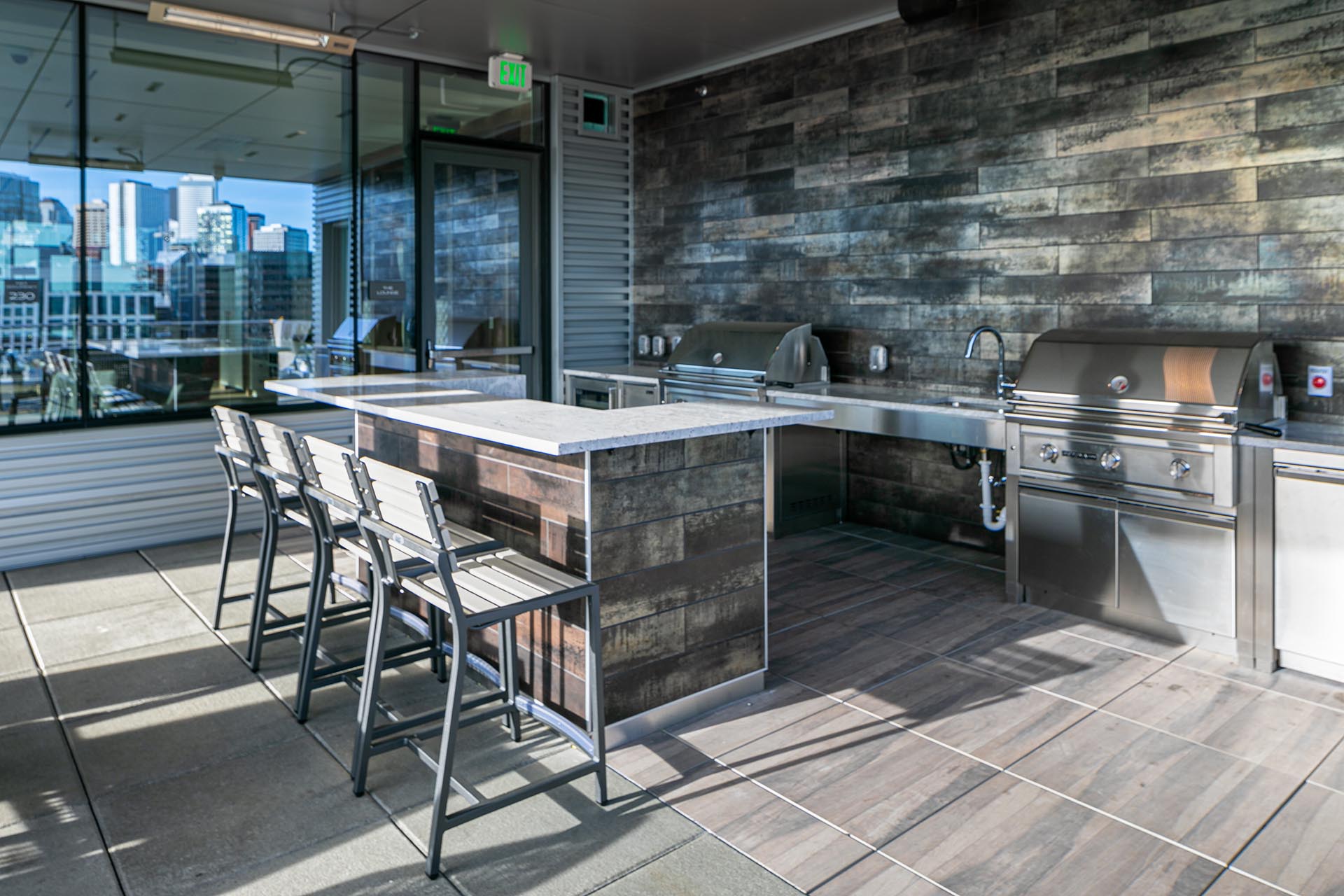 Outdoor deck seating with cooking area including sink and grills
